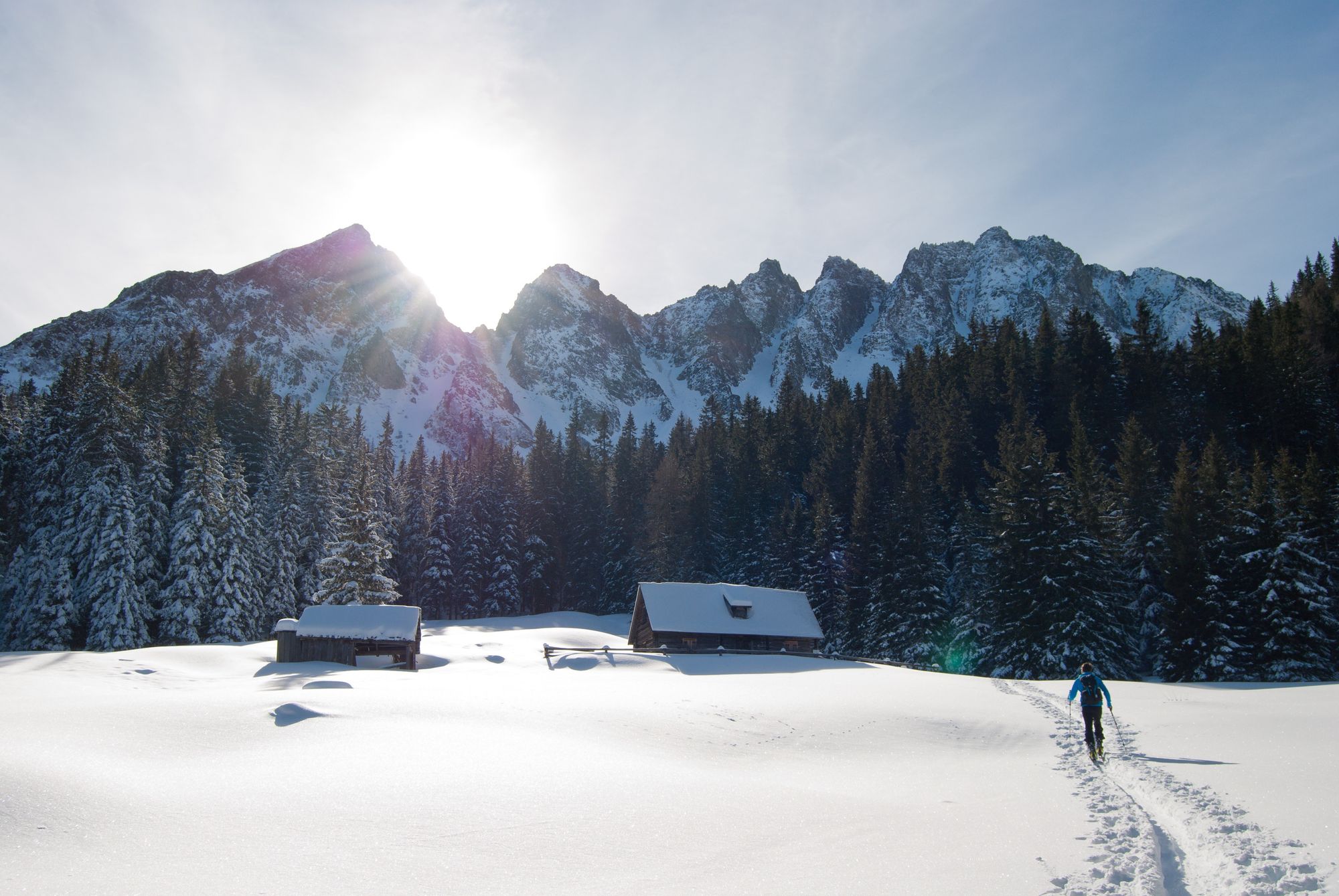 Man Walking Towards Brown Housen in a Snow Place